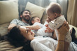 © Evgenij Yulkin/Stocksy - Smiling family relaxing on bed at home