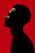 © Leandro Crespi/Stocksy - African American man portrait profile silhouette isolated over red - Eyes closed
