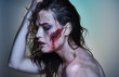 Beautiful girl with a wounded face in the blood
