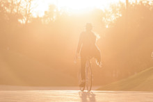 Male's Silhouette Riding Vintage Bicycle In The Golden Hour