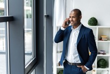 Handsome African American Businessman Talking On Mobile Phone In Modern Office.