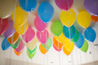 © Leigh Love/Stocksy - Colorful Balloons Filled With Helium Float On The Ceiling