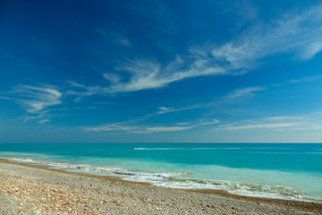 Stone beach with water jet and blue sky