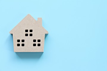 Business, finance, savings, money management, property loan or mortgage concept :  Top view or flat lay of wood house model on blue background with copy space ready for adding or mock up