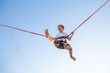 © Georgii - Smilling excited boy jumping on a trampoline with insurance.