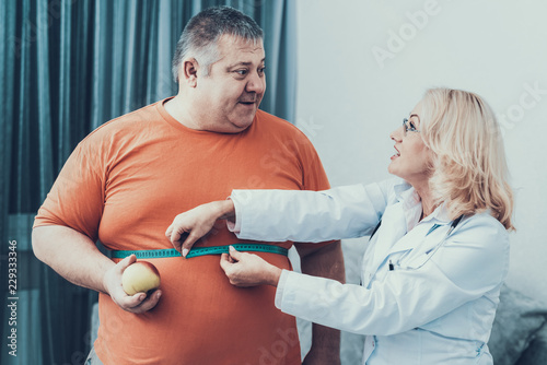 Fotografía Fat Man with Doctor in White Coat in Gray Room.