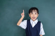 Leinwandbild Motiv Asian chinese little girl in uniform pointing finger up