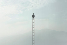 Surreal Image Of A Man Who Is Sitting On A Very High Ladder In The Middle Of Nature