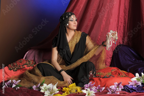 Fotografie, Obraz chic woman in oriental costume with beads in her hands