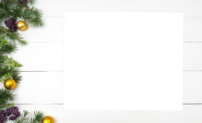 Creative Christmas layout. Fir twigs and golden balls. White wood background whit copy space. Border arrangement. Flat lay top view.