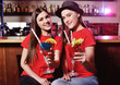 © Evgeniy Kalinovskiy - two cute young girlfriend girls are drinking cocktails in a nightclub or bar, having fun and talking