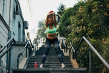 Fototapeta Miasto - Portrait of  sporty young woman doing stretching in city.
