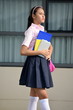 Posing Asian Female Student Wearing Skirt With Notebooks
