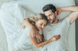 © LIGHTFIELD STUDIOS - top view of beautiful young couple sleeping together in bed at home