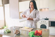 © estradaanton - Young woman is pouring some milk into glass bowl with eggs. There are plenty of food at the table. Girl is cooking.