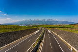 Fototapeta Do pokoju - Scenic view of highway leading to rocky peaks of High Tatras mountains, Slovakia summer day.
