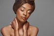 © LIGHTFIELD STUDIOS - portrait of beautiful african american woman with head wrap and bare shoulders isolated on grey