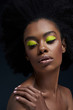© LIGHTFIELD STUDIOS - portrait of beautiful african american model with bright neon makeup and bare shoulders isolated on black