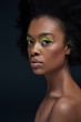 © LIGHTFIELD STUDIOS - portrait of beautiful african american model with bright neon makeup and bare shoulders isolated on black