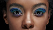 © LIGHTFIELD STUDIOS - cropped shot of african american woman with blue eye shadows looking at camera isolated on black