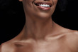 © LIGHTFIELD STUDIOS - cropped shot of smiling african american woman with bare shoulders isolated on black