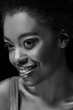 © LIGHTFIELD STUDIOS - black and white photo of beautiful smiling african american woman isolated on black