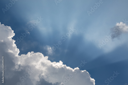 Fotografie, Obraz Beautiful blue sky with sun rays emerging behind the clouds