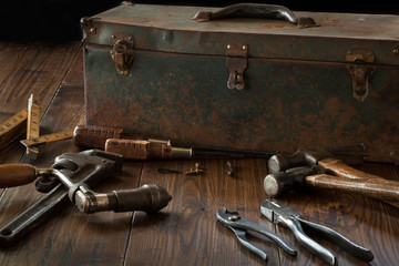 Antique tools and toolbox on dark wood surface