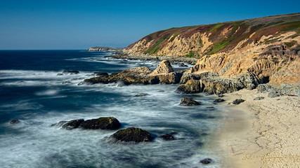 Landscape view of Bodega Bay beach in Sonoma County in California, USA, on a typical summer day in the morning, featuring blue water and blue sky