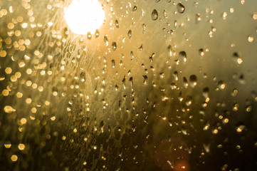 raindrops on window glass on background of cloudy sky