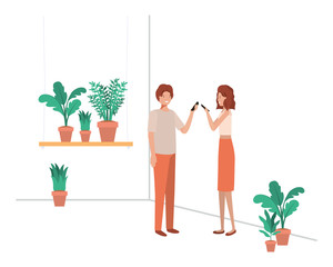 young couple with house plant and smartphone