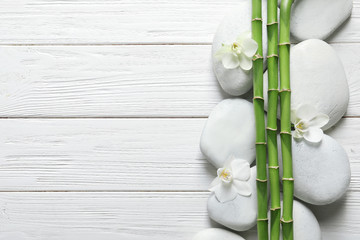 Flat lay composition with green bamboo stems on wooden background. Space for text