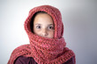Young girl bundled with pink knitted scarf.