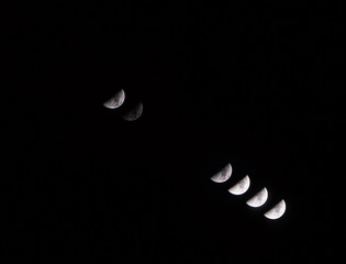 Multiple exposures of the Moon in the night sky.