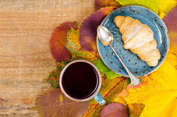 Canvas Print - Hot tea, croissant, autumn maple leaves