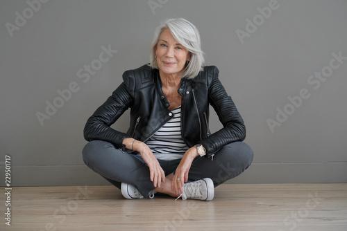Fotografía Modern senior woman sitting indoors with leather jacket