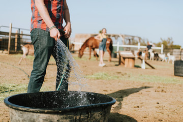 Farmer filling a tub with water