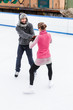Romantic figure ice skater couple dancing together on ice rink