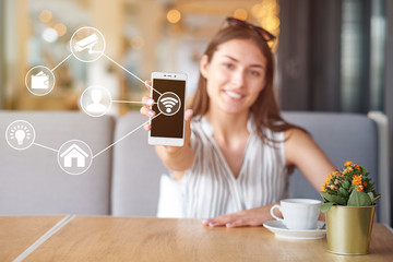 Woman using modern mobile smart phone connecting to wifi automation apps. Remote virtual control at home.