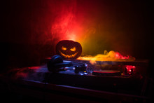 Halloween Pumpkin On A Dj Table With Headphones On Dark Background With Copy Space. Happy Halloween Festival Decorations And Music Concept
