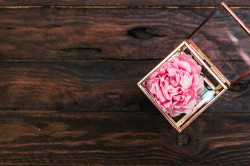 Sticker - pink peony flowers on wooden background. Minimal flat lay composition with copy space.