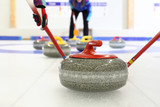 Fototapeta Kamienie - Gra w curling. Zawodnik gra w curling na lodowisku

