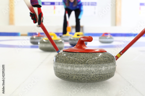 Fotografía Gra w curling. Zawodnik gra w curling na lodowisku