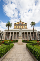 Outside facade of the Papal Basilica of St. Paul outside the Walls (it.: Basilica Papale di San Paolo fuori le Mura) against blue sky