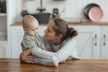 Mom gently and firmly hugs baby 10 months, cozy