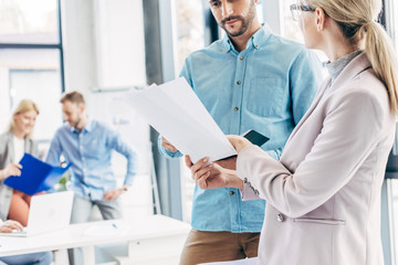 cropped shot of young businessman and businesswoman  working together in office