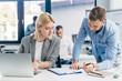 © LIGHTFIELD STUDIOS - young businessman and businesswoman working with papers and laptop in office