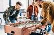 © LIGHTFIELD STUDIOS - group of young casual businessmen playing table football at office and having fun together