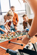 © LIGHTFIELD STUDIOS - cropped shot of young casual business people playing table football at office and having fun together
