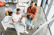© LIGHTFIELD STUDIOS - high angle view of young entrepreneurs looking at whiteboard at office
